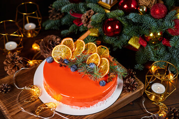 Christmas mousse cake decorated with blueberries and dried orange slices on the background of...