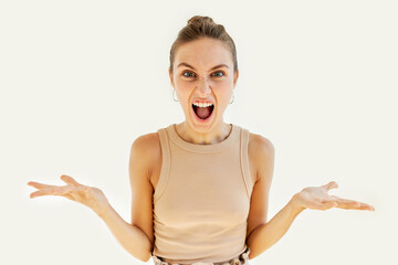 Horizontal portrait of frustrated, angry and extremely furious female with hair bun screaming and...
