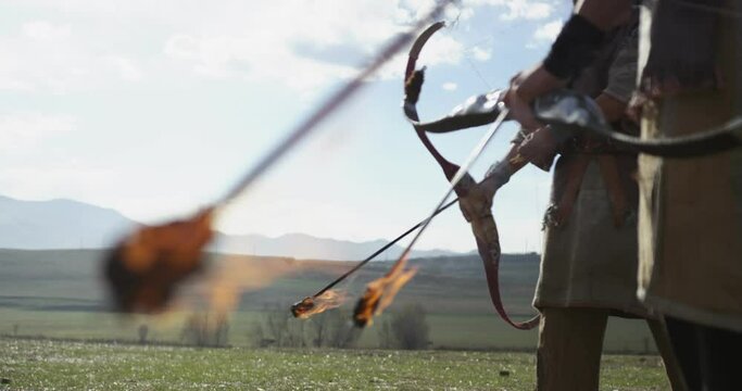 Ancient Warriors hold bows with burning arrows
