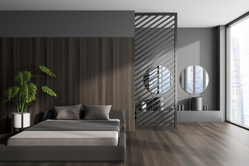 Front view on dark studio interior with bed, grey wall