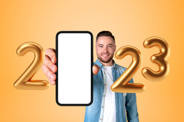Happy man holding a smartphone with mockup blank display, 2023 y