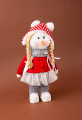 A snowwoman is a Christmas toy in a warm hat and pants. New Year and Christmas.