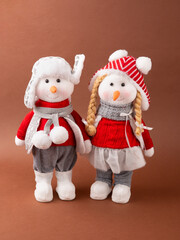 A pair of snowmen girl and boy Christmas toy in a warm hat and pants. New Year and Christmas.