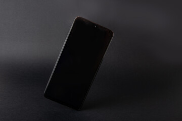Black blank phone screen on a dark background
