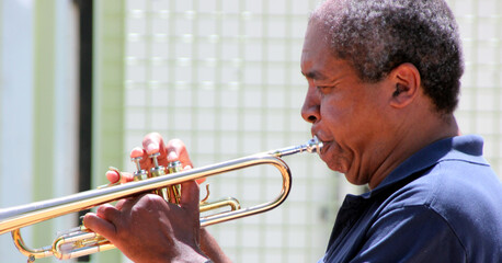 African american jazz reumpet player blowing his horn outside.