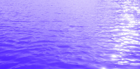 The gentle waves of the sea or lake are bright blue and the sunlight reflects on the water surface. In the morning, beautiful and soft