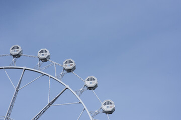 Cabins of a Ferris wheel against the blue sky in the city of Barcelona, Spain