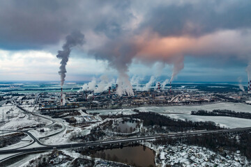 Fototapeta premium winter panoramic aerial view of the smoke of pipes of a chemical plant or woodworking enterprise. Air and water pollution concept.