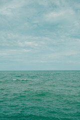 Obraz premium The front view in the morning sky is bright blue with clear white clouds. And the ocean deep indigo in daylight. Feeling calm, cool, relaxing. The idea for cold background and copy space on the top.