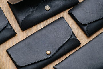 Black faux leather purses with clip buttons. Flat lay top view close up.