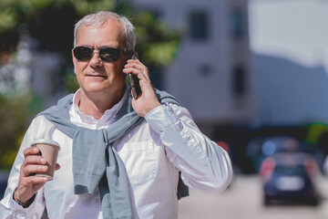 adult man with takeaway coffee and teledono on the street