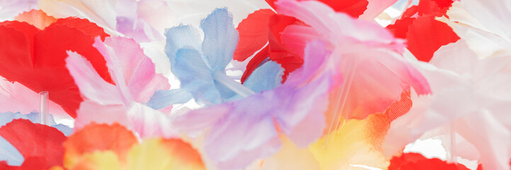 Colorful panoramic background. Colorful plastic hawaii flowers