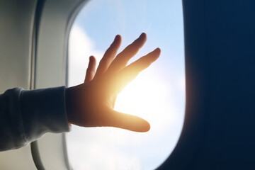 travel concept  Tourist hand touching plane window with beautiful sunset