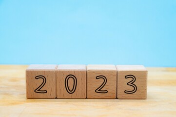 Number 2023 in wooden blocks on blue background with copy space. new year concept