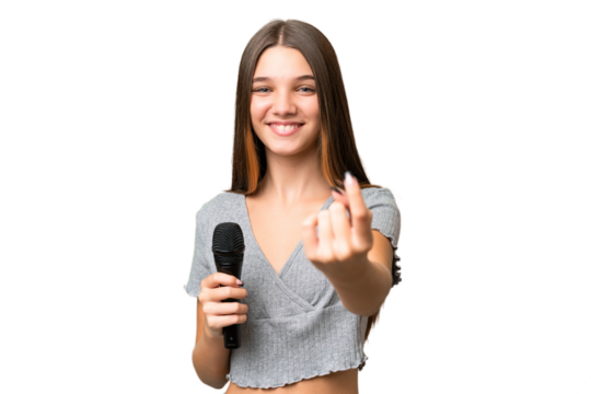 Teenager singer girl picking up a microphone over isolated background doing coming gesture