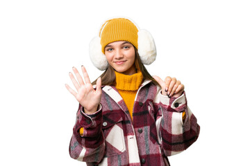 Teenager caucasian girl wearing winter muffs over isolated background counting six with fingers