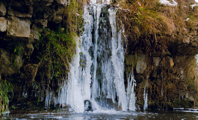 small beautiful waterfall in the winter time. waterfall with ice