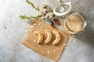 Healthy cookies, homemade almond crescents without sugar but oat flakes and dates on baking paper,...