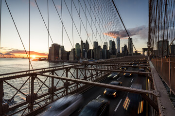 Rushhour am Abend auf der Brooklyn Bridge mit Manhattan im Hintergrund.