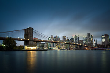 Naklejka na ściany i meble Brooklyn Bridge mit New Yoek Skyline zur blauen Stunde.