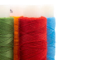 Spools of colored threads on a white background with an empty space for an inscription