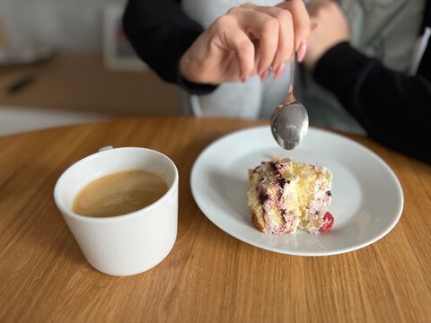 person holding a cup of coffee and cake