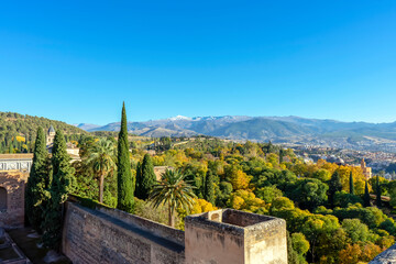 Green gardens of Alhambra on mountains peak covered by snow in Granada, Spain on November 26, 2022