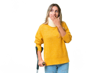 Young Uruguayan woman wearing neck brace and crutches over isolated background with surprise and shocked facial expression