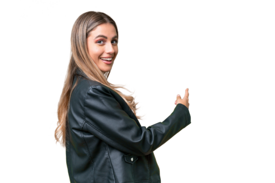 Business pretty Uruguayan woman wearing a biker jacket over isolated background pointing back
