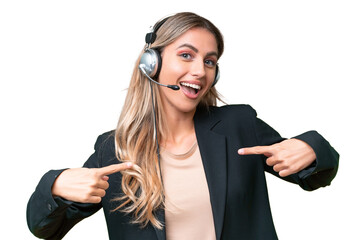 Telemarketer pretty Uruguayan woman working with a headset over isolated background proud and...