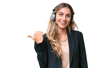Telemarketer pretty Uruguayan woman working with a headset over isolated background pointing to the...