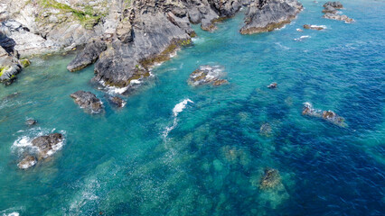 Steep cliffs on the southern coast of Ireland. Turquoise waters of the Atlantic Ocean. Natural beauties of Ireland, West Cork. The rocky coast of the Celtic Sea. Drone point of view.