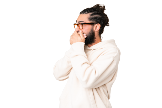 Young man with beard over isolated chroma key background covering mouth and looking to the side