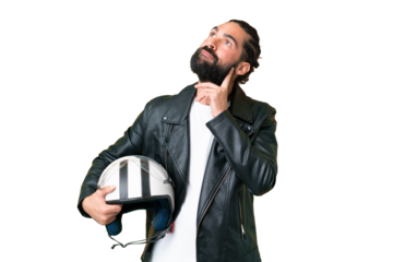 Young man with beard with a motorcycle helmet over isolated chroma key background thinking an idea while looking up