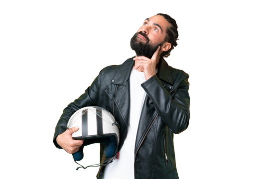 Young man with beard with a motorcycle helmet over isolated chroma key background thinking an idea while looking up