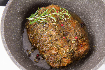 Raw pork loin seasoned - ready to be roasted, in a pot	
