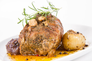 Roast pork loin with onions and garlic, decorated with rosemary and some colorful peppercorns