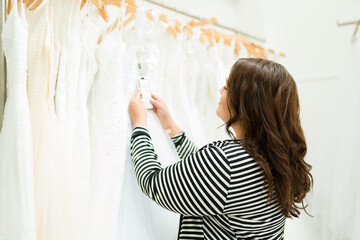 Chubby woman seen from behind looking for a wedding gown