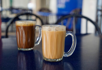 Black coffee and milk tea mugs served on the street of Malaysia                               