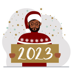 A man in a red sweater and with a cap holds a sign or poster with the numbers 2023. Postcard or greeting Merry Christmas and Happy New Year.