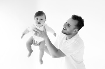 father plays with 7-month-old baby, black and white photo