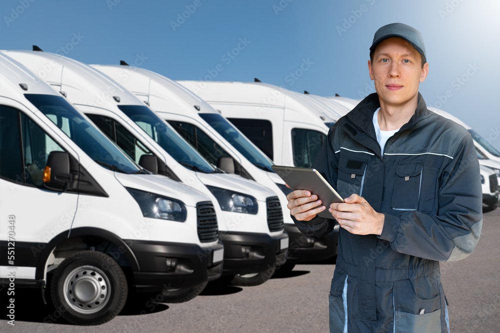 Aufkleber manager with a digital tablet on the background of vans. fleet management