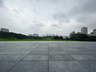 Empty square in the foreground and city buildings in the distance