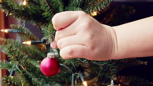 Christbaumkugel wird an den Christbaum geh&auml;ngt