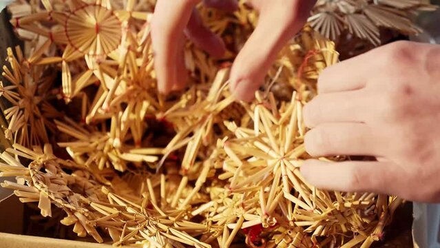 Zwei H&auml;nde w&uuml;hlen und finden den passenden Strohstern