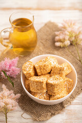 Traditional turkish delight (rahat lokum) with glass of green tea on a white wooden background....