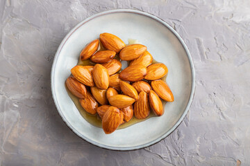 Almonds with honey on gray concrete. top view, close up.