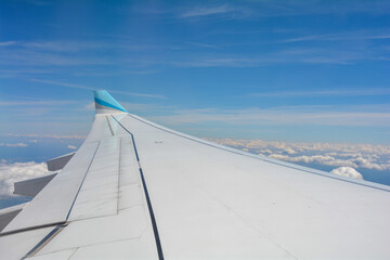 Obraz premium View from an airplane window showing the wing and sky with clouds