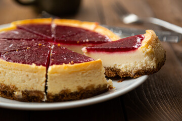 Cheesecake with raspberry jam on a wooden table