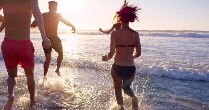 Friends, waves and water splash at beach during sunset on fun holiday adventure, ocean vacation and group travel to Bali. Friendship, happiness and group love while playing with freedom in summer sun